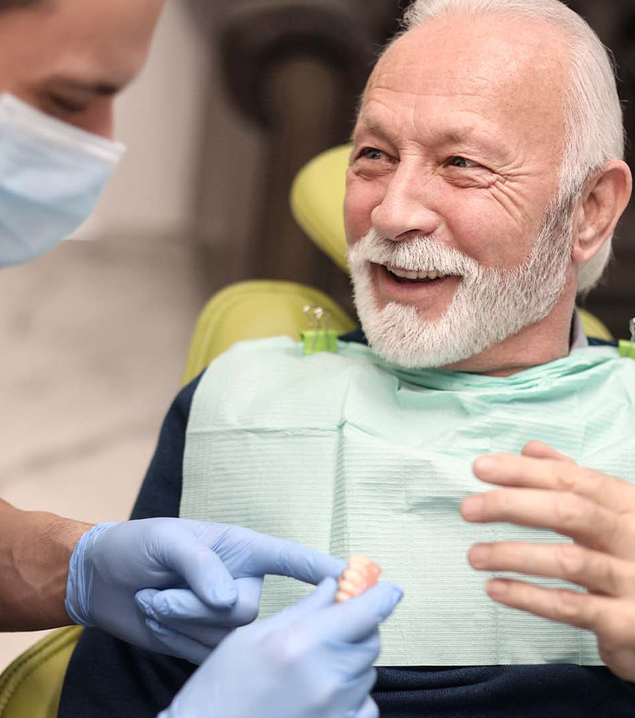 Stock image of a doctor explaining about dentures to an old male patient